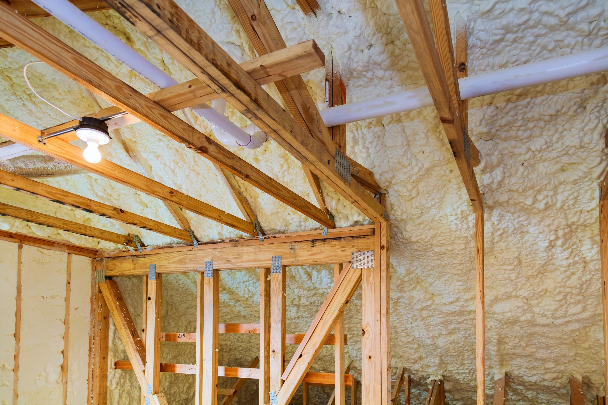 Foam plastic insulation installed in the sloping ceiling of a new frame house.